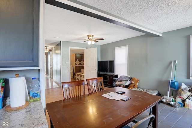 dining area with ceiling fan, a textured ceiling, and dark hardwood / wood-style floors