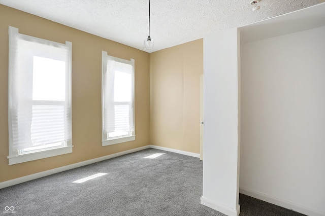 empty room with a textured ceiling and carpet flooring