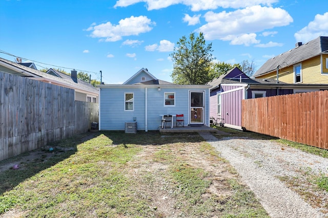 back of house featuring a patio area and a lawn