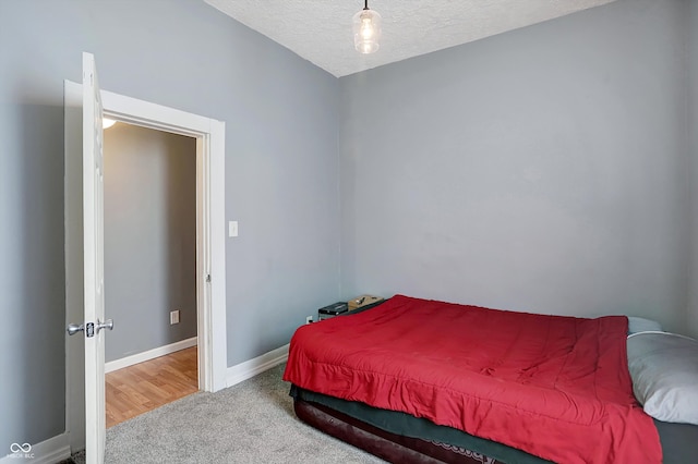 bedroom featuring a textured ceiling and carpet floors