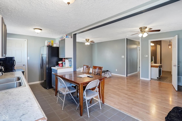 dining room featuring sink, ceiling fan, a textured ceiling, and dark hardwood / wood-style flooring