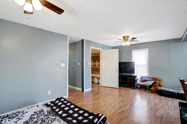 bedroom with a textured ceiling, wood-type flooring, and ceiling fan