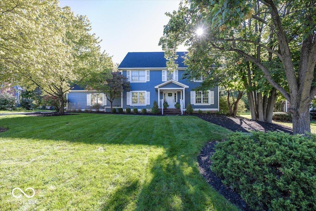 colonial-style house with a front lawn