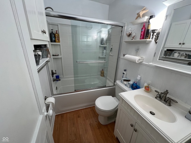 full bathroom featuring toilet, vanity, wood-type flooring, and shower / bath combination with glass door