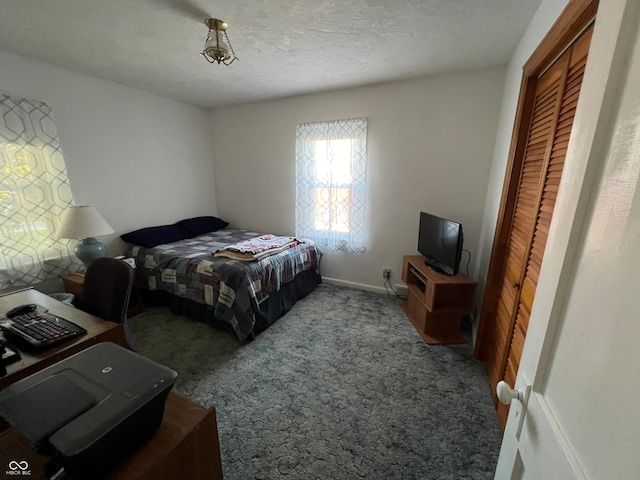 carpeted bedroom with a textured ceiling and a closet