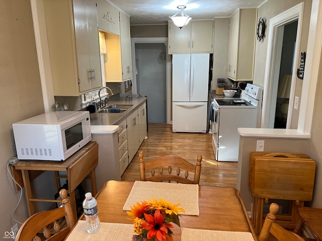 kitchen featuring a textured ceiling, sink, white cabinetry, light hardwood / wood-style flooring, and white appliances