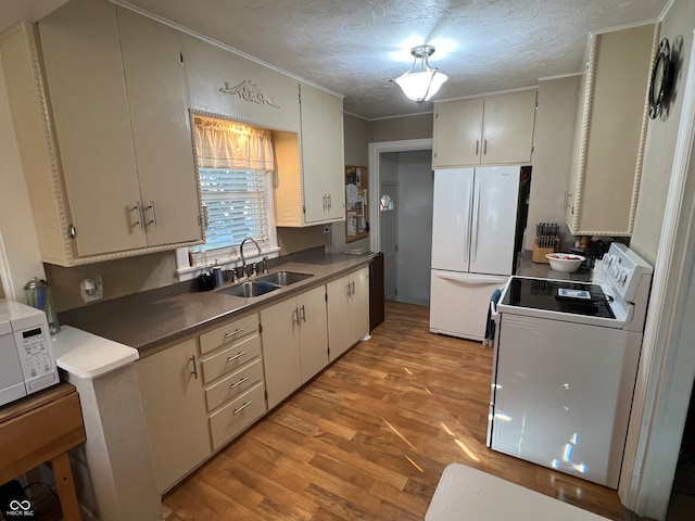 kitchen featuring white appliances, white cabinetry, sink, and light hardwood / wood-style flooring