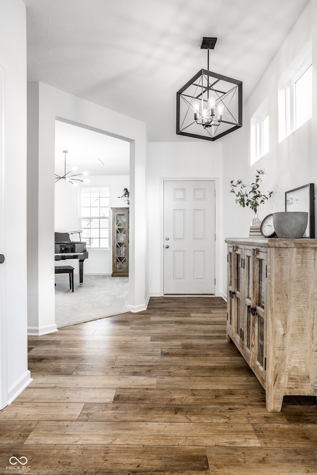 entrance foyer with hardwood / wood-style flooring, a healthy amount of sunlight, a textured ceiling, and ceiling fan with notable chandelier