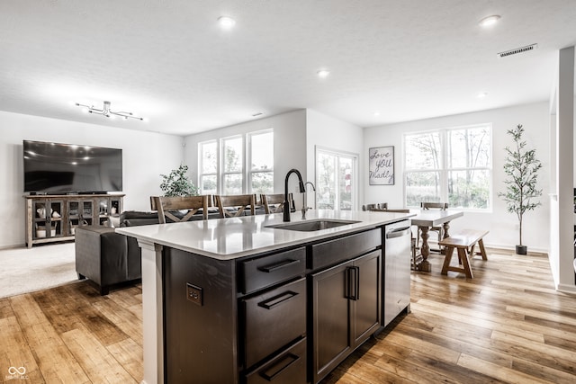 kitchen featuring sink, dishwasher, an island with sink, and a healthy amount of sunlight