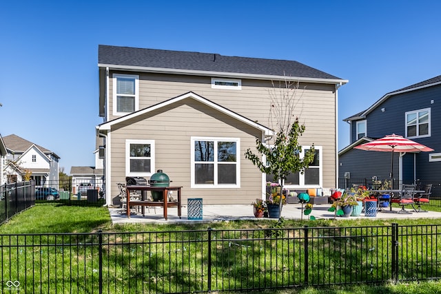 rear view of house with a yard and a patio