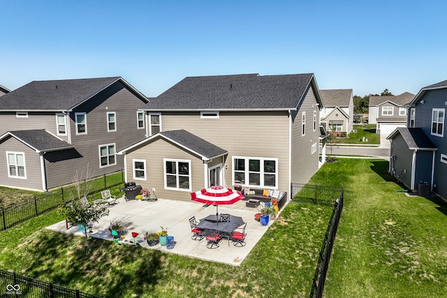 rear view of house featuring a storage unit, a yard, and a patio