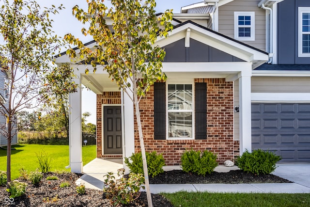 property entrance featuring a garage and a lawn