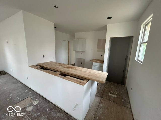 kitchen with a breakfast bar, white cabinets, and kitchen peninsula