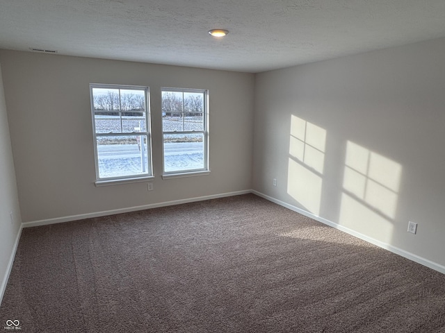 carpeted empty room with a textured ceiling