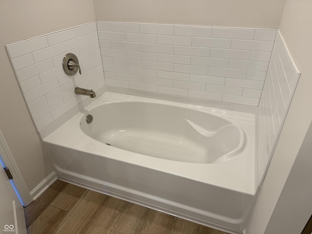 bathroom featuring wood-type flooring and a bathing tub