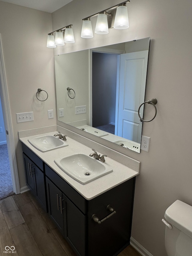 bathroom with hardwood / wood-style flooring, vanity, and toilet