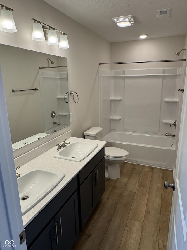 full bathroom featuring vanity, hardwood / wood-style flooring, toilet, and tub / shower combination