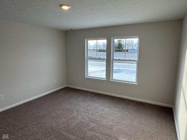 carpeted empty room with a textured ceiling