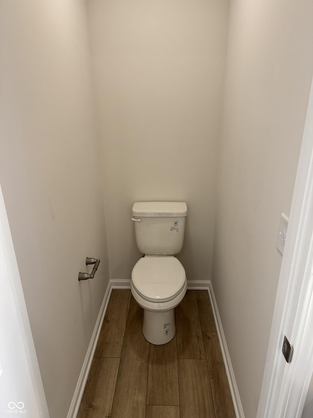 bathroom with hardwood / wood-style flooring and toilet