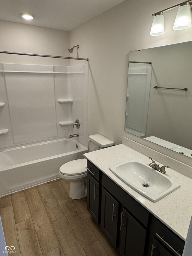 full bathroom with washtub / shower combination, wood-type flooring, vanity, and toilet