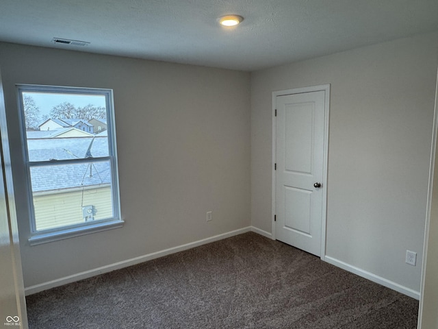 carpeted spare room with a textured ceiling