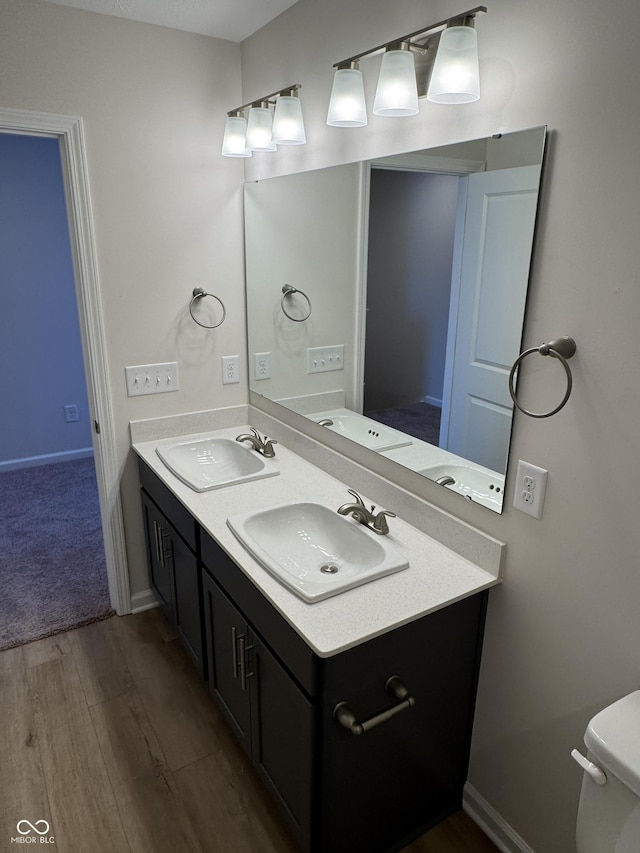 bathroom featuring vanity, wood-type flooring, and toilet