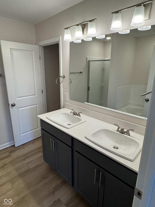 bathroom featuring hardwood / wood-style floors, vanity, a textured ceiling, and independent shower and bath