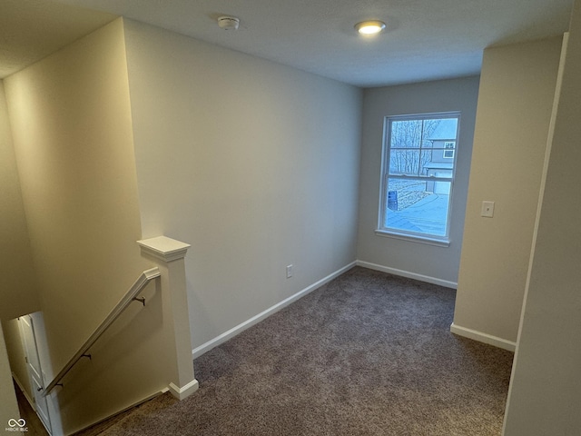 unfurnished room with dark colored carpet