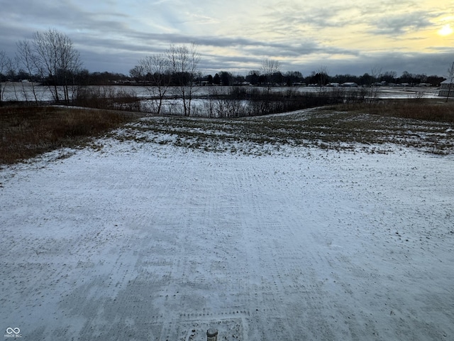 snowy yard featuring a rural view