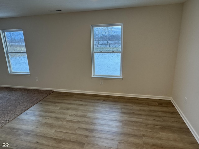 spare room with a healthy amount of sunlight and light hardwood / wood-style floors