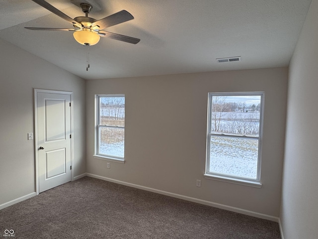 carpeted empty room with a textured ceiling, ceiling fan, and lofted ceiling