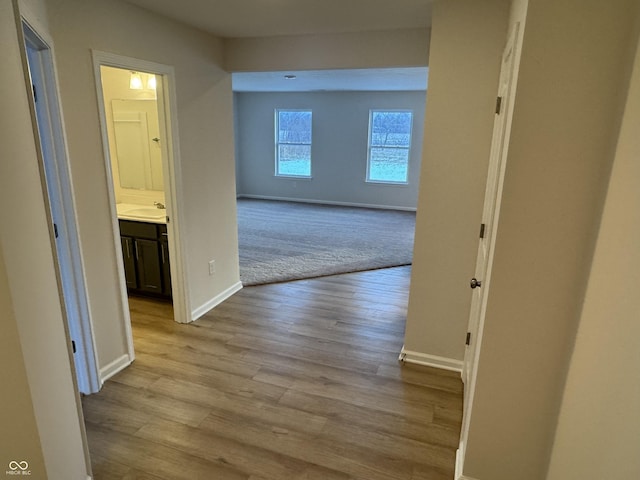 hallway with light hardwood / wood-style flooring and sink