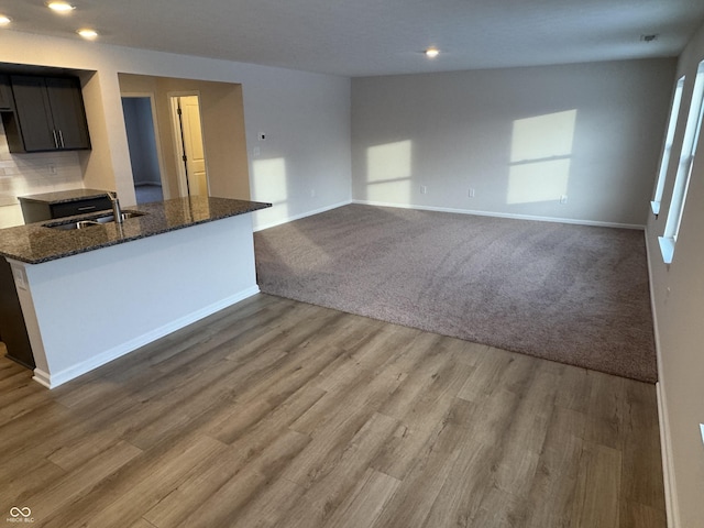 interior space with carpet, dark stone counters, and sink