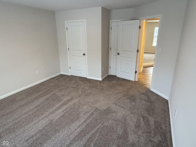 unfurnished bedroom with dark carpet