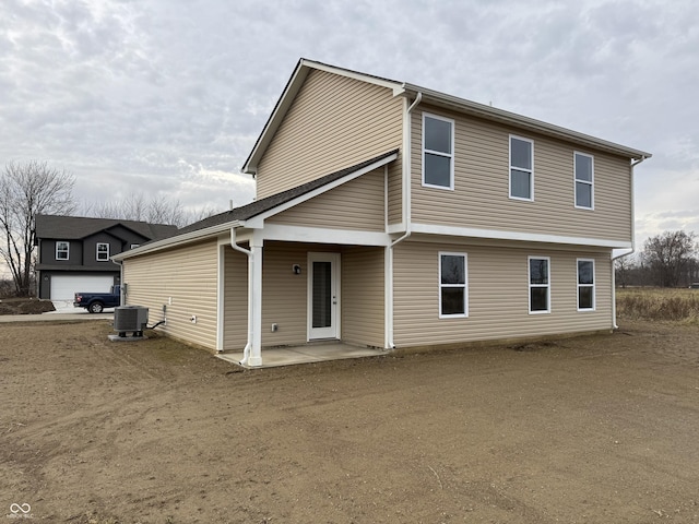 rear view of house with central AC and a patio area