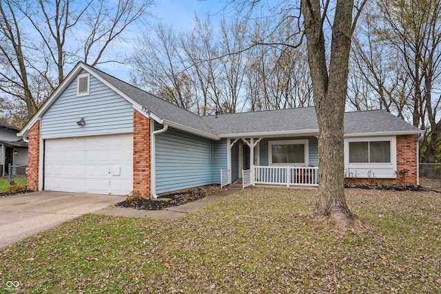 ranch-style home featuring a front lawn, covered porch, and a garage