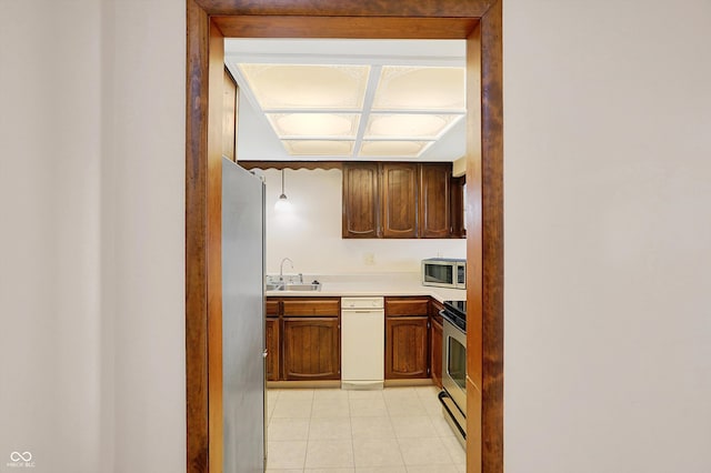 kitchen with light tile patterned floors, appliances with stainless steel finishes, and sink