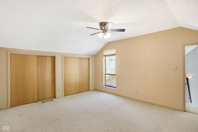 bonus room with lofted ceiling, light carpet, a textured ceiling, and ceiling fan