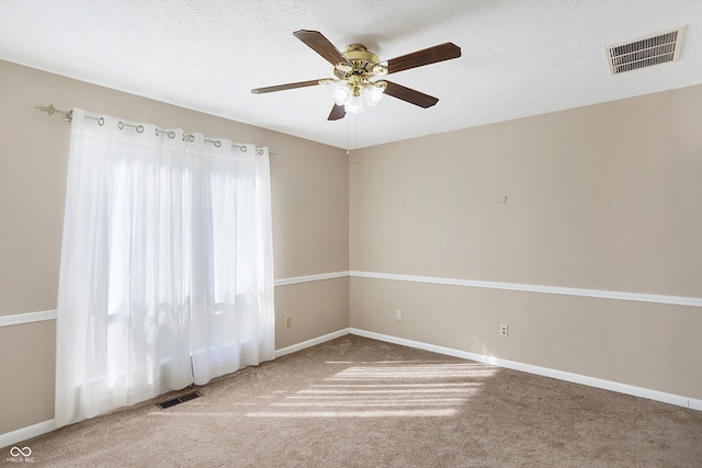 empty room with ceiling fan, a textured ceiling, and carpet floors