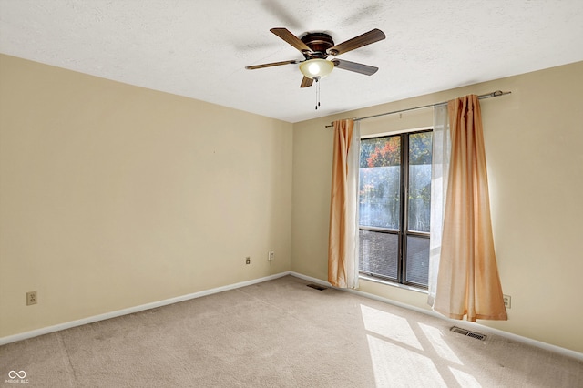 carpeted empty room featuring a textured ceiling and ceiling fan