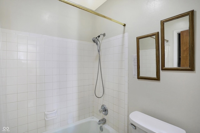 bathroom featuring toilet and tiled shower / bath