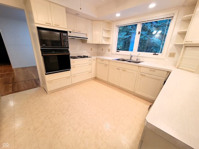 kitchen featuring sink, black oven, white gas cooktop, and white cabinets