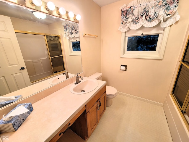 bathroom with vanity, toilet, and an enclosed shower