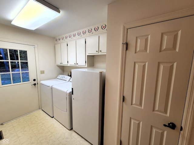 laundry room featuring washing machine and clothes dryer and cabinets