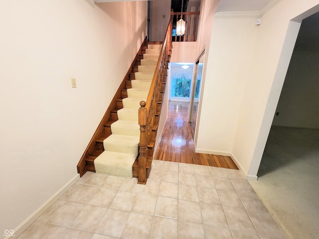 staircase featuring crown molding and hardwood / wood-style floors