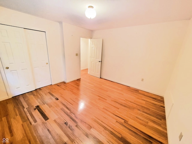 unfurnished bedroom with a closet and hardwood / wood-style floors