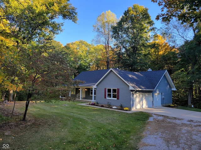 view of front of home featuring a front yard, covered porch, and a garage