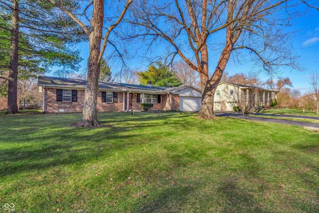 ranch-style home featuring a garage and a front yard