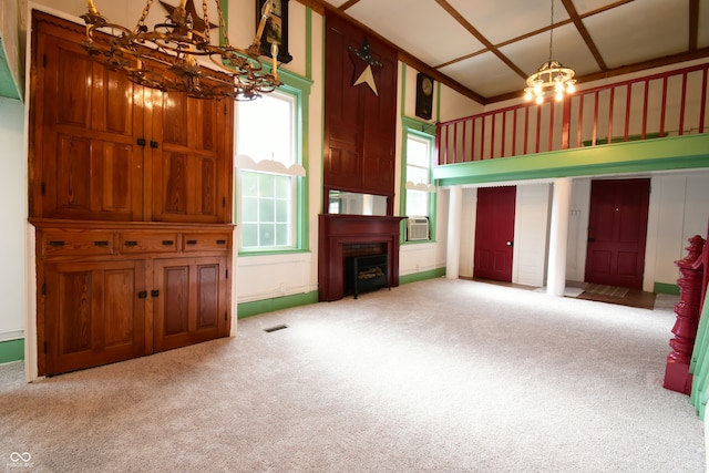 unfurnished living room with a notable chandelier and carpet floors