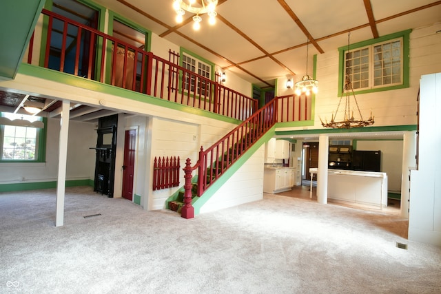 unfurnished living room with carpet and a high ceiling